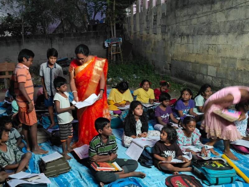 A teacher with children at an Akshara Dhaathree study centre