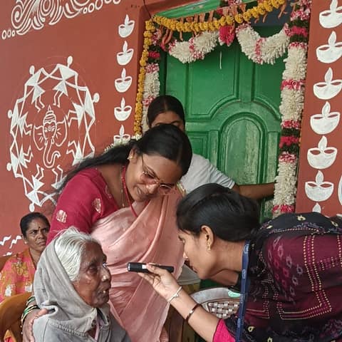 An eye check-up for an elderly woman at a health camp